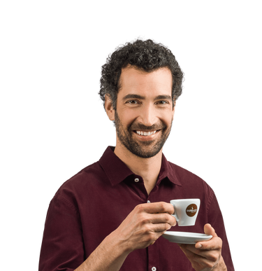 Lächelnder Mann hält eine Kaffeetasse vor sich in der rechten Hand und Untertasse in der linken Hand