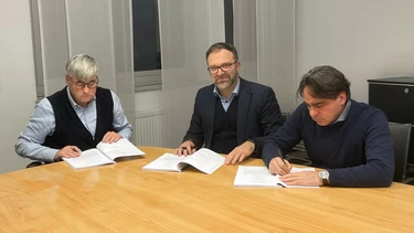 Thomas Karl, Fritz Kaltenegger und Holger Karl an einem Tisch beim Signieren von Verträgen