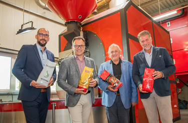 Gerald Matzner, Fritz Kaltenegger, Ilija Barisic, und Marco Salvatori mit Kaffeepackungen im Röstwerk